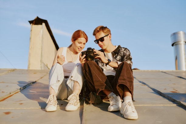 户外微笑的情侣查看相机中的照片图片下载