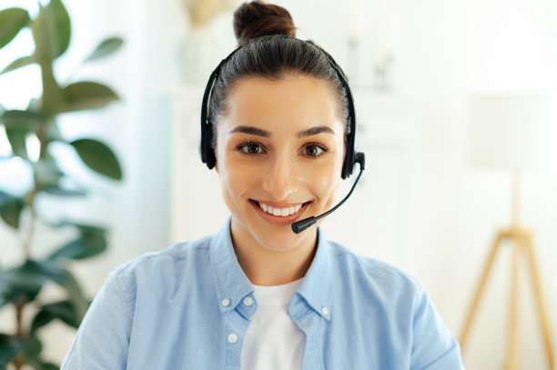 自信的棕发白人女性，佩戴耳机，作为呼叫中心客服在线咨询客户的特写照片图片下载