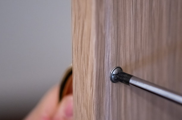 男人将螺丝拧入壁橱的特写照片图片下载