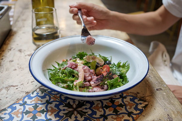 一位女性在厨房台面上享用意大利沙拉开胃菜的特写照片图片下载