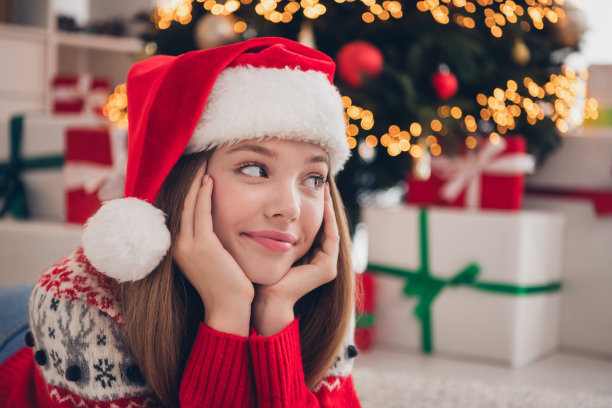 特写照片，漂亮的女士躺在地板上，感兴趣地望向窗外，欣赏雪天，享受室内温馨的季节时光。图片下载