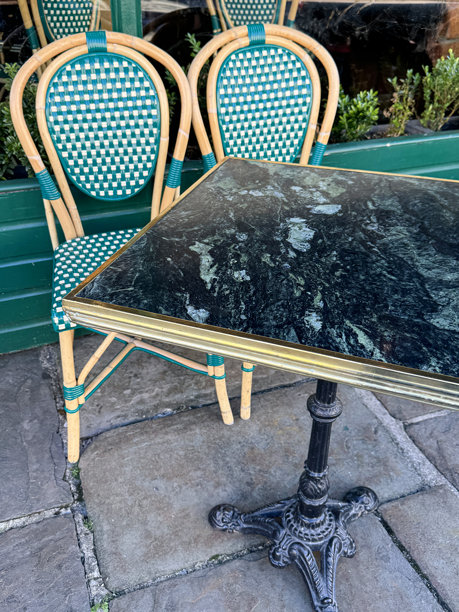 法式小酒馆的图片/ 绿色藤编餐桌和椅子放在铺砌的人行道上图片下载