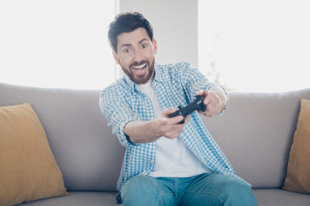 独自在家玩游戏机，手持操纵杆的成熟男人照片图片下载