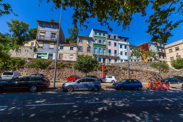 这张图片展示了波尔图一个山坡社区，展现了一排色彩斑斓的传统葡萄牙房屋。图片下载