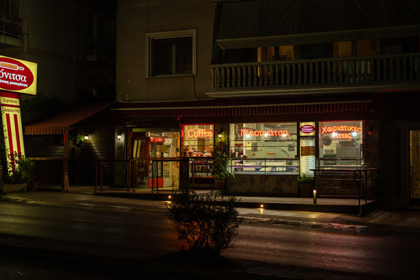 照片展示了雅典市夜间的街头小吃店，出售传统商品。城市生活概念。图片下载