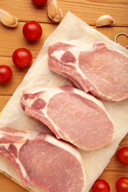 切好的生猪肉放在木质背景的切菜板上。垂直照片图片下载