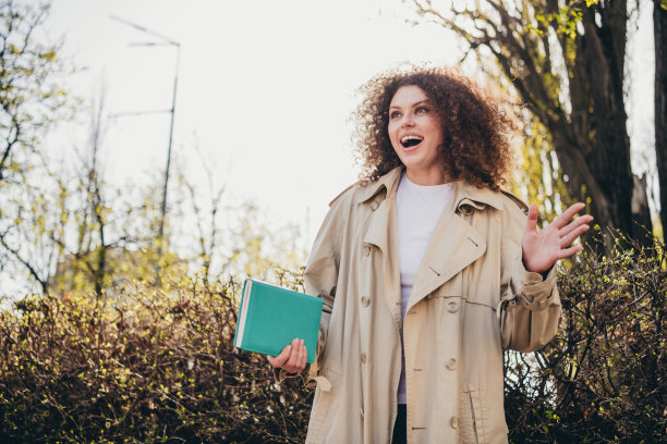 在公园户外，工作日后意外相遇的时尚风衣打扮的有趣、快乐、可爱的女孩照片图片下载
