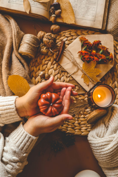 女孩手中燃烧的蜡烛，俯视图，温馨的秋季照片，图片下载