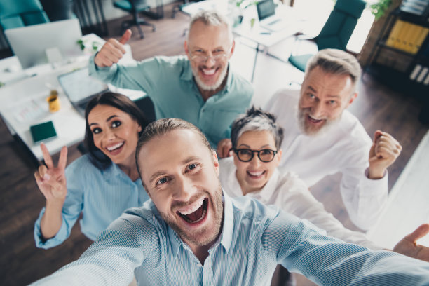 照片：办公室内，团队合作项目，人们庆祝胜利并自拍图片下载
