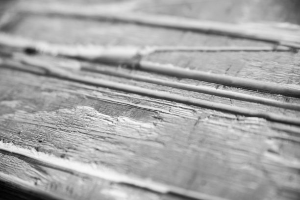 黑白照片，展示剥落的白漆下的木纹特写图片下载