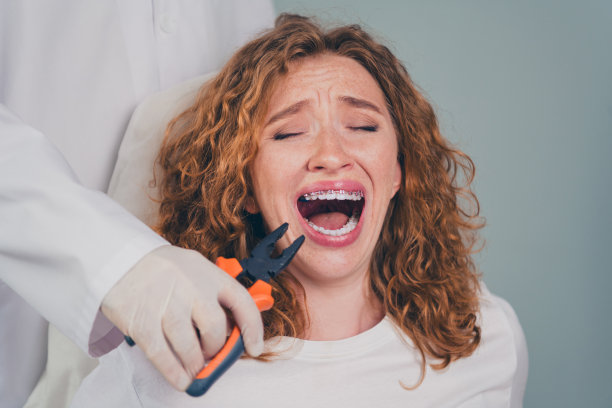 专业牙医进行牙齿拔除的照片，紧急护理中一位害怕的女性在医疗中心就诊。图片下载