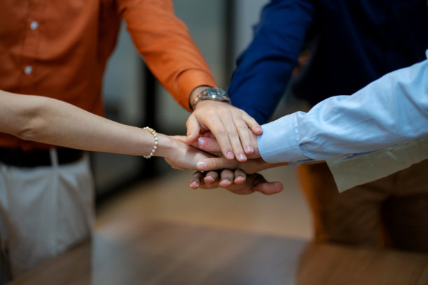多种族商业专业人士的特写镜头，手叠在一起象征团结，代表团队合作、成功和企业协作。突显工作场所的多样性、领导力和相互支持，这张图片捕捉了企业的本质。图片下载