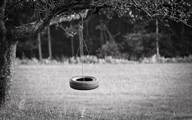 废弃的秋千，使用旧轮胎制作。悲伤、孤独或童年概念照片。图片下载
