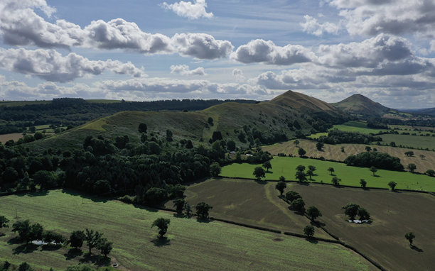 空中照片显示了远处的劳利山和卡拉多克山，周围是不同农业阶段的田野。图片下载