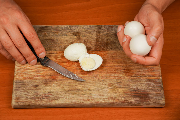 男人手持鸡蛋在木板上。煮鸡蛋。准备食物。横向照片。素食者。蛋白质。运动员的食物。健康食品。桌子上的煮鸡蛋特写。图片下载