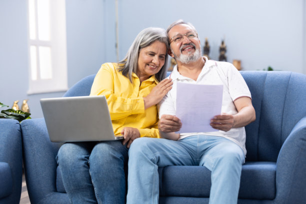 快乐的成熟夫妇使用笔记本电脑，同时计划他们的家庭预算库存照片图片下载