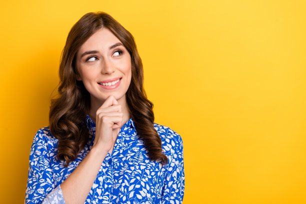 照片中甜美梦幻的女子穿着蓝色上衣，手臂下巴看起来空空荡荡，孤立的黄色背景图片下载