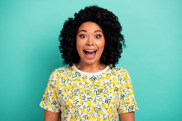 照片中激动迷人的女士穿着印花t恤，张开嘴，空白空间孤立的蓝绿色背景图片下载