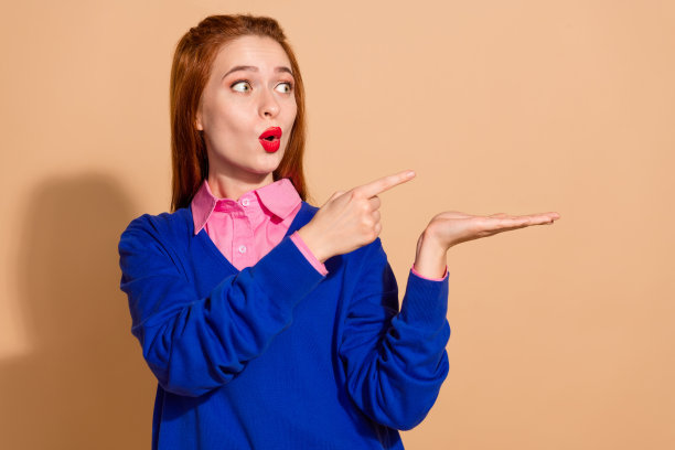 照片正面印象深刻的女士穿蓝色套头衫显示手指抱臂空空间孤立米色背景图片下载