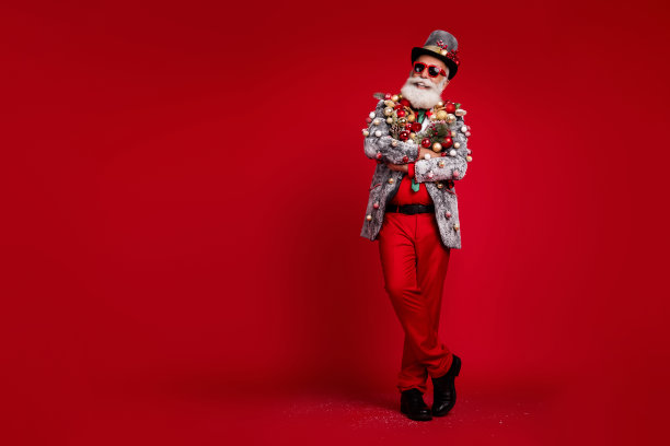 全身照片自信有趣的男人双手交叉自信戴圣诞树球服装太阳镜孤立的红色背景图片下载