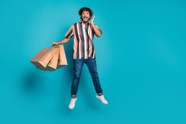 漂亮的年轻男子的全尺寸照片购物袋跳穿衬衫孤立的蓝绿色背景图片下载