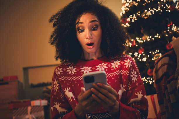 迷人的年轻女子的照片震惊惊奇拿装置穿着装饰装备舒适的新年装饰花环家室内客厅图片下载