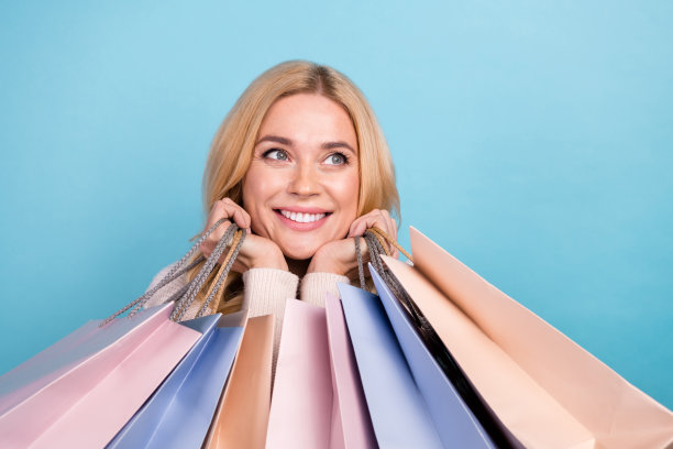 照片中可爱可爱的女人穿着时髦的白色衣服，拿着包裹，在蓝色的背景下看起来空无一物图片下载