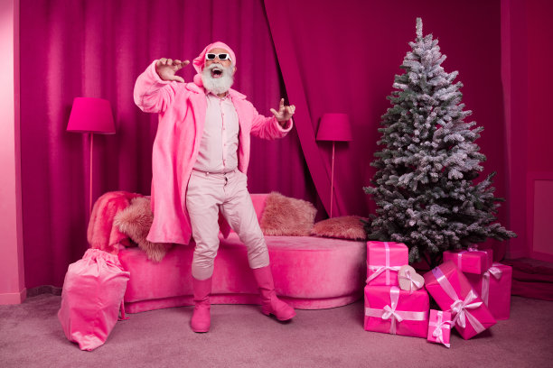 有趣的照片酷退休老人跳舞的圣诞老人皮大衣靴子蓬松的睡衣帽子太阳镜粉红色的圣诞派对装饰室内x-mas图片下载