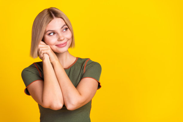 可爱可爱的女孩的照片与鲍勃发型穿着卡其布t恤梦幻般的看着销售空白空间孤立的黄色背景图片下载