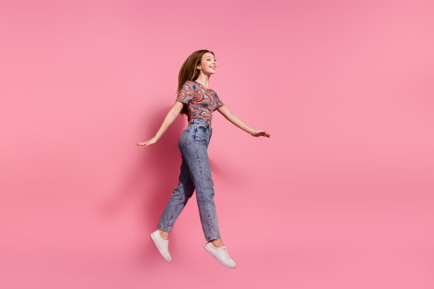 完整的照片可爱的少女女士跳跑走穿着时尚的印花衣服孤立在粉红色的背景图片下载