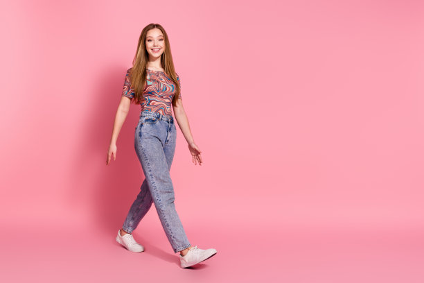 愉快满意的女孩穿印花t恤牛仔裤的全长照片去出售空白空间孤立在粉红色的背景图片下载