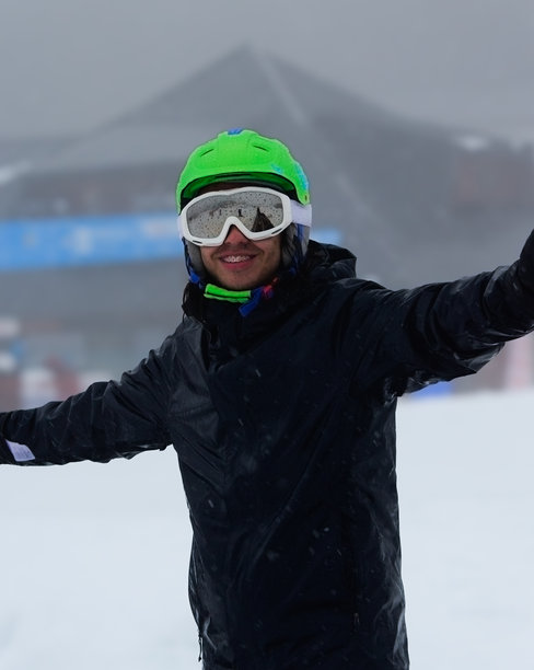 戴着头盔和眼镜的男子开心地准备滑雪板图片下载