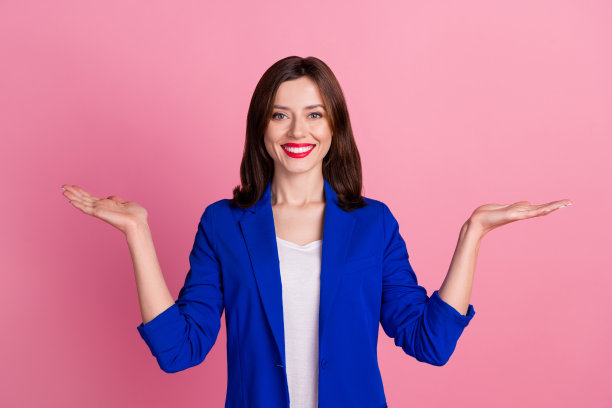 年轻满意的女商人蓝色正装夹克的照片老板企业家展示手掌选择最好的产品质量隔离在粉红色的背景图片下载