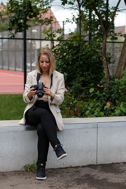 女人坐在户外查看相机照片图片下载