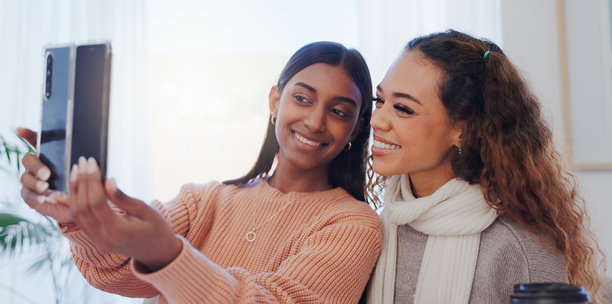 自拍，朋友和微笑的女性，家中客厅的亲密时光，内容创作者和发布。房子，摄影和影响者的回忆，快乐的个人资料照片，在休息室一起度过。图片下载