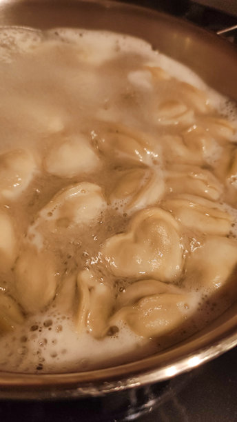 心形饺子在沸水中煮。垂直手机照片图片下载