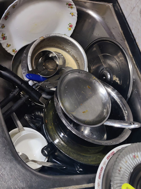 一堆脏盘子和平底锅坐在厨房的工作台上——库存照片图片下载