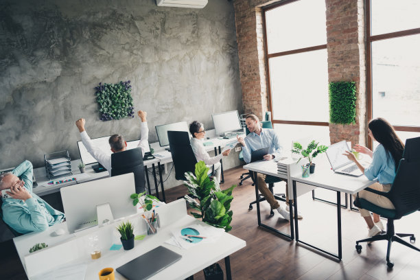 全景照片，展示了在明亮的办公室中，团队成员围坐在桌子旁，共同进行项目工作和会议，展现出成功的合作氛围。图片下载