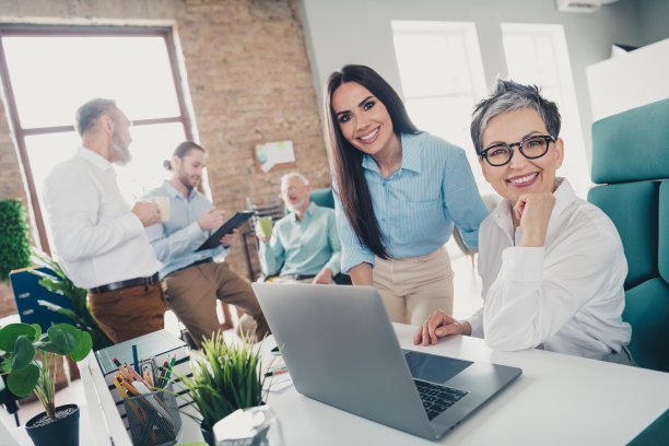 团队合作的创业伙伴在舒适、创意的创业办公室内使用电脑进行网络交流的照片图片下载