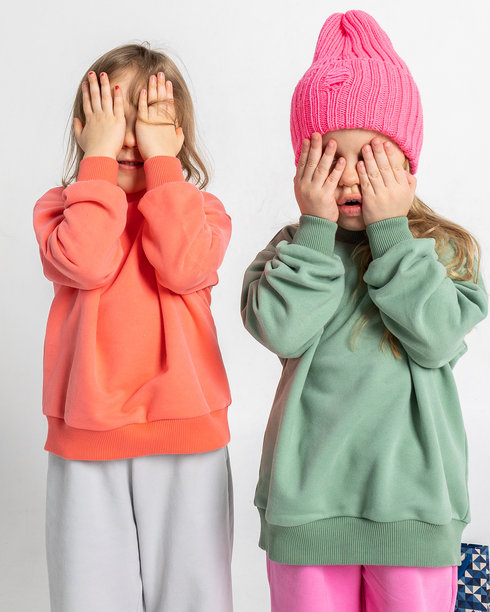 两个可爱搞笑的女孩在玩耍和享受乐趣。孩子们面带微笑，表情搞笑，背景明亮。竖版照片图片下载