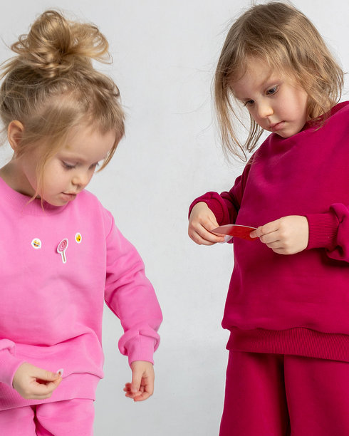 两个可爱搞笑的女孩在玩耍和享受乐趣。孩子们面带微笑，表情搞笑，背景明亮。竖版照片图片下载