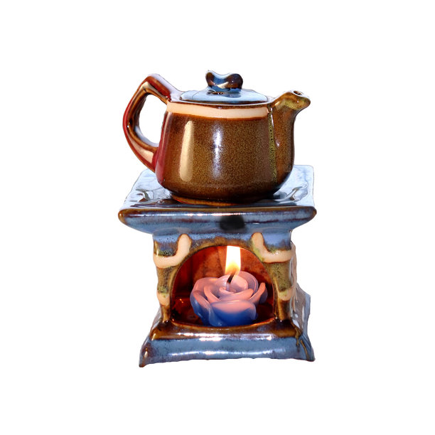 带有燃烧蜡烛的陶瓷茶壶烛台 - 彩色照片，适合设计使用。图片下载