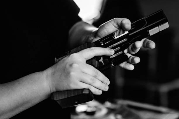 女人在家中持手枪的中部特写图片下载