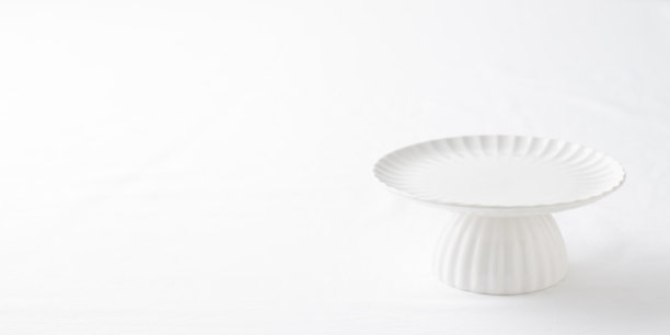 空的餐具 - 白色盘子和蛋糕架在白色桌子上，作为甜点横幅照片的背景，留有空白空间，食品样板图片下载