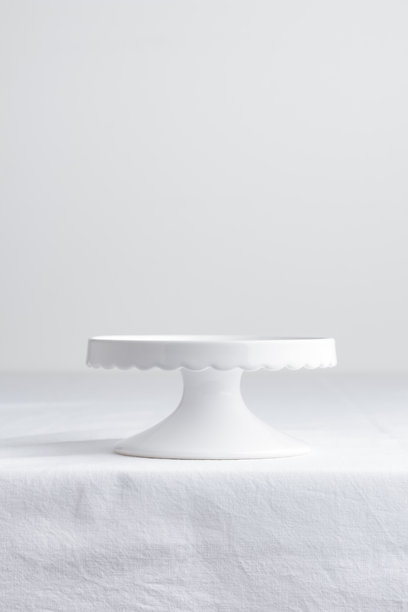 空的餐具 - 白色盘子和蛋糕架在白色桌子上，作为甜点的背景，垂直照片带有留白，食品样机图片下载