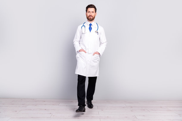专业合格医生穿着白大褂走在灰色墙壁背景前的全身照片图片下载