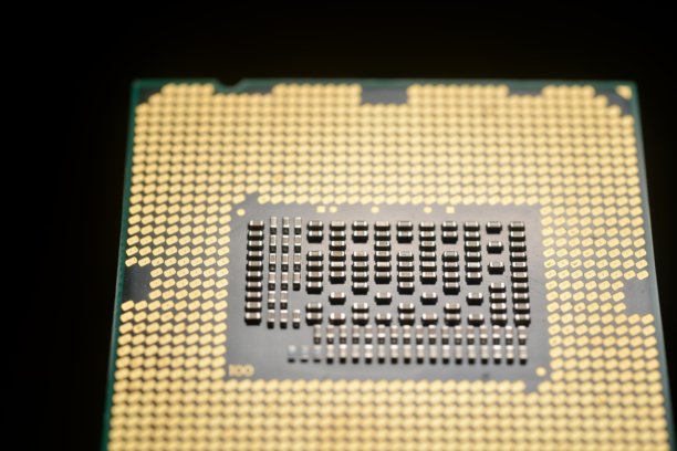 一张微处理器芯片的特写宏观照片，背景为深色。芯片复杂的设计和金色接触点清晰可见。图片下载