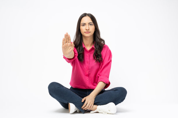 开朗可爱的女人穿着时髦的衣服，坐在地板空空间孤立的白色背景股票照片图片下载