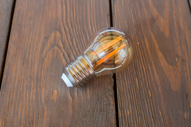 复古风格的LED爱迪生灯放在古老的乡村桌子上图片下载