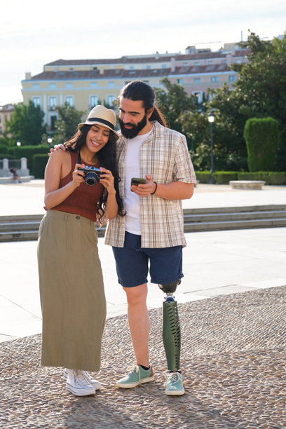 快乐的游客情侣在查看数码相机和智能手机上的照片图片下载